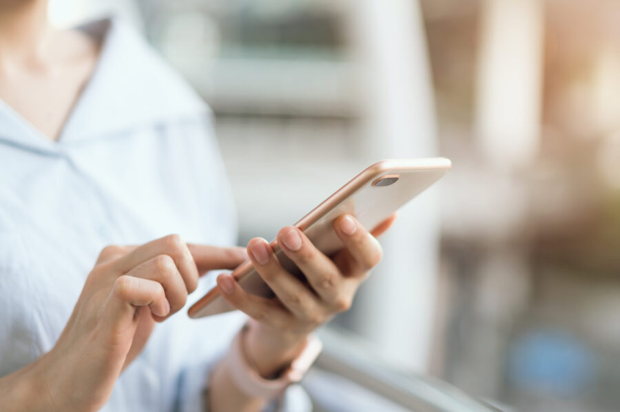 woman using smartphone on staircase in public areas, During leisure time. The concept of using the phone is essential in everyday life.